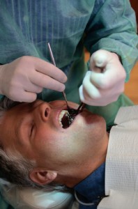 The dentist surgically secures the metal implant into the patient’s jaw bone.